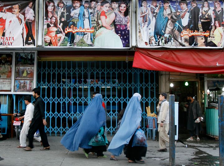 Women walk past a cinema in Kabul Afghanistan. Although women are legally allowed to go to the movies, much of Afghan society considers it inappropriate with some even saying its forbidden by Islam.