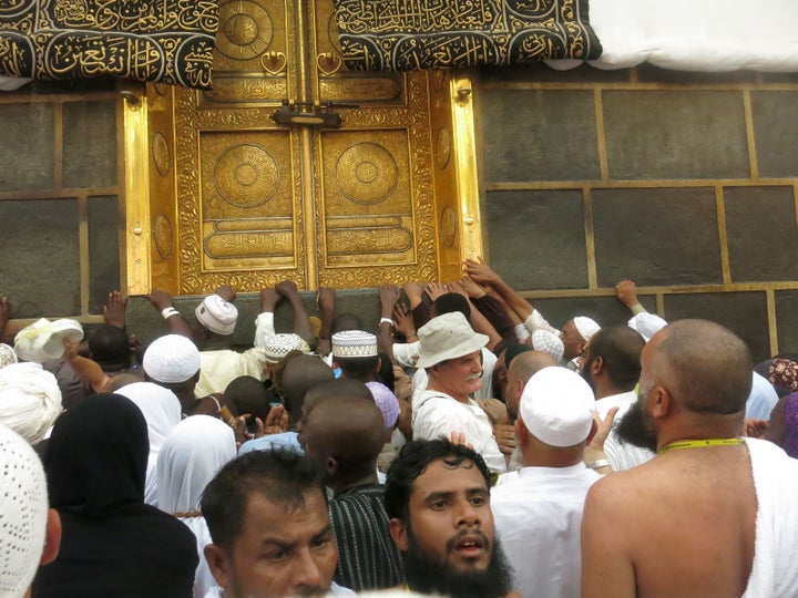 Muslim pilgrims touch the golden doors of the Kaaba, Islam's holiest shrine, at the Grand Mosque in Saudi Arabia's holy city