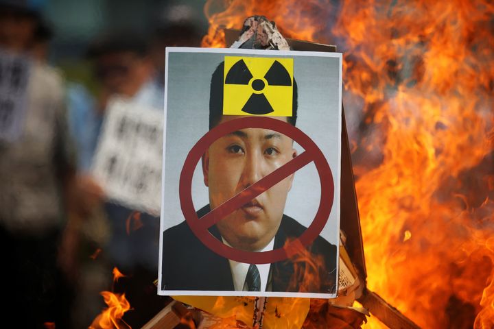 A cut-out of North Korean leader Kim Jong Un is set on fire during an anti-North Korea rally in central Seoul, South Korea, one day after the isolated nation conducted its fifth nuclear test.