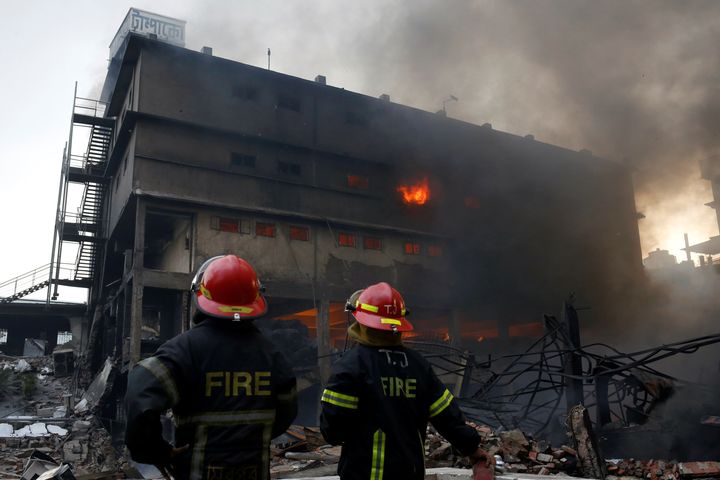 Firefighters stand at the site of a fire at a packaging factory outside Dhaka, Bangladesh, September 10, 2016.