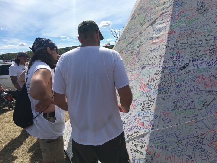 A teepee near the protests is covered in signatures and messages of support.