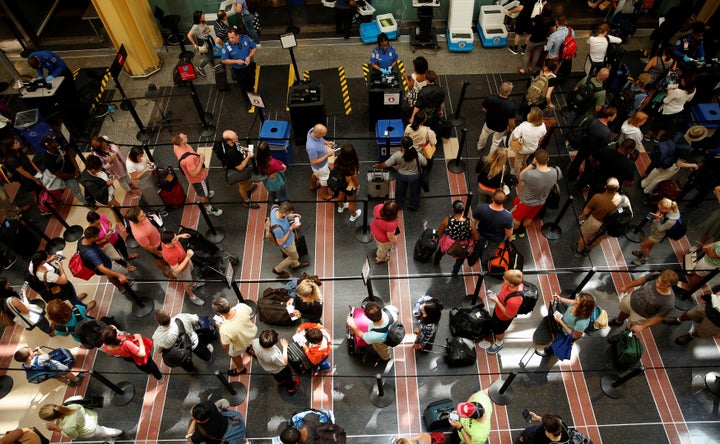 Passengers make their way through a TSA checkpoint at Reagan National Airport at the start of the Independence Day holiday weekend in Washington, U.S., July 1, 2016.