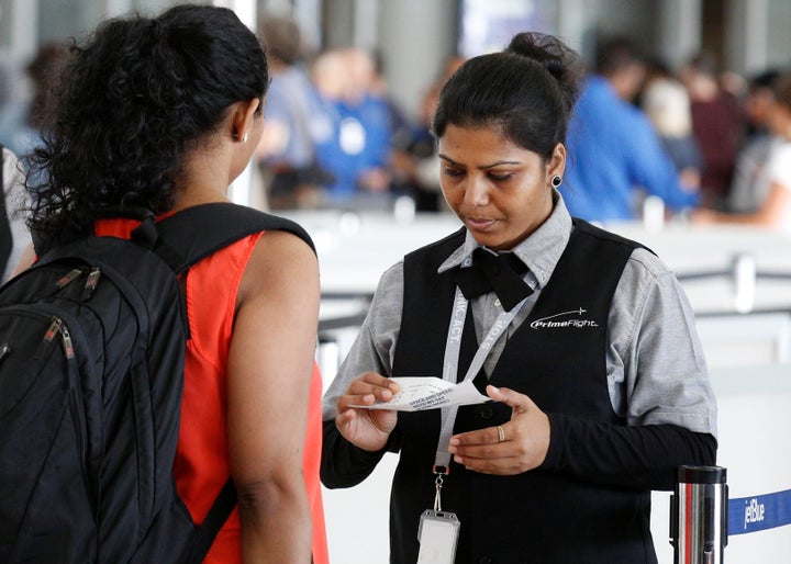 An airport private contractor prepares a passenger at a security checkpoint during the check-in process at JFK airport in New York City in May 2016.