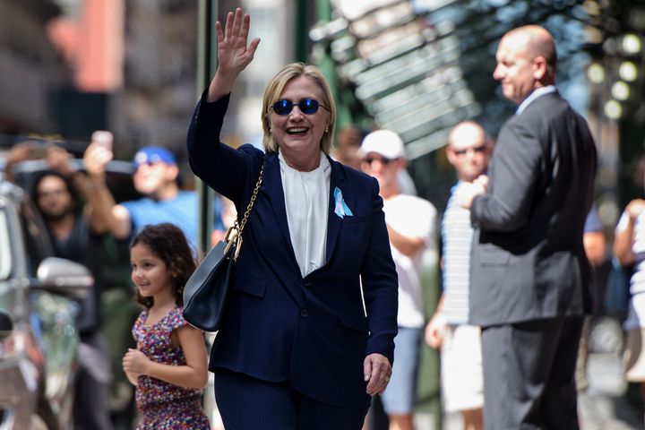 Democratic presidential nominee Hillary Clinton waves to the press as she leaves her daughter's apartment building in New York City. Clinton departed from a remembrance ceremony on the 15th anniversary of the 9/11 attacks after feeling 'overheated,' but was later doing 'much better,' her campaign said