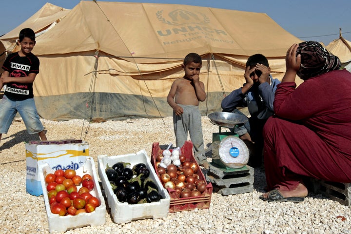 A Syrian refugee woman sells vegetables at the Zaatari refugee camp, home to more than 55,000 Syrians, located close to the Jordanian city of Mafraq, near the border with Syria on January 3, 2013.