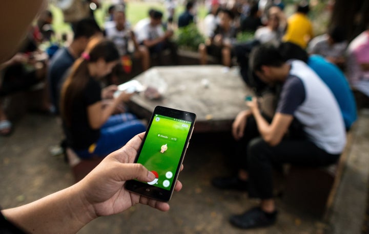 Gamers play Pokemon Go at the Quezon City Memorial Circle in Manila.