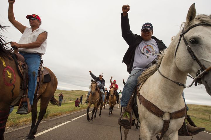Native Americans ride with raised fists to a sacred burial ground that was disturbed by bulldozers building the Dakota Access Pipeline (DAPL) on September 4, 2016 near Cannon Ball, North Dakota.