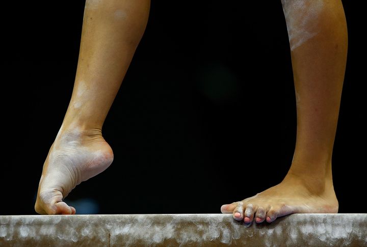 Gymnasts warm up on the balance beam prior to competing in the senior women preliminaries during the 2014 P&G Gymnastics Championships on August 21, 2014.