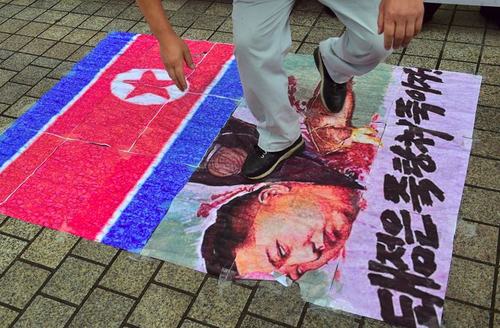 A South Korean activist tramples on an caricature picture of North Korean leader Kim Jong-Un during a protest denouncing North Korea's latest nuclear test in Seoul on September 12, 2016.