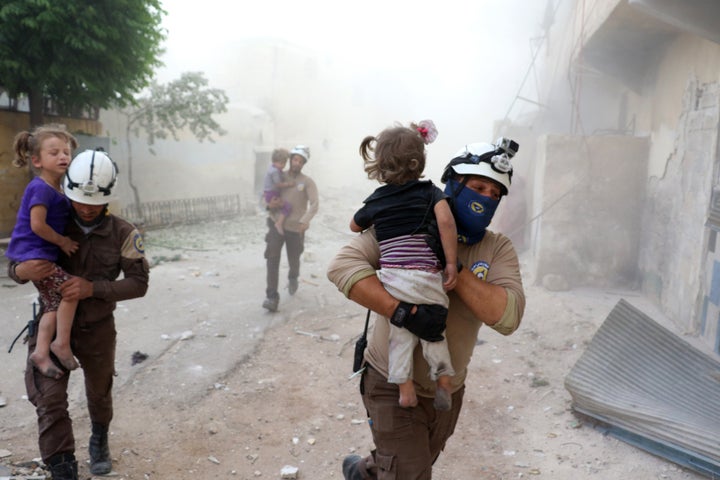 Search and rescue team members carry wounded children after an Assad forces' airstrike hit residential areas in Tal Zarazir Neighborhoof of Sukkeri District of Aleppo, Syria.