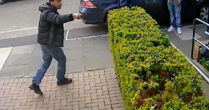 <strong>The young man raises the knife appearing to threaten the victim as his flees the scene</strong>