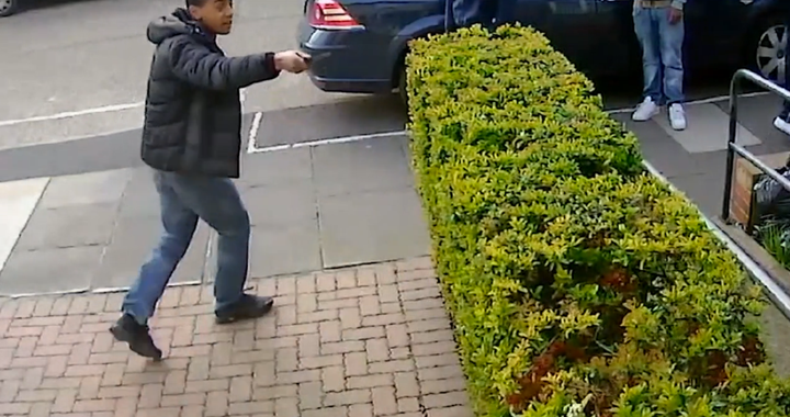 The young man raises the knife appearing to threaten the victim as his flees the scene