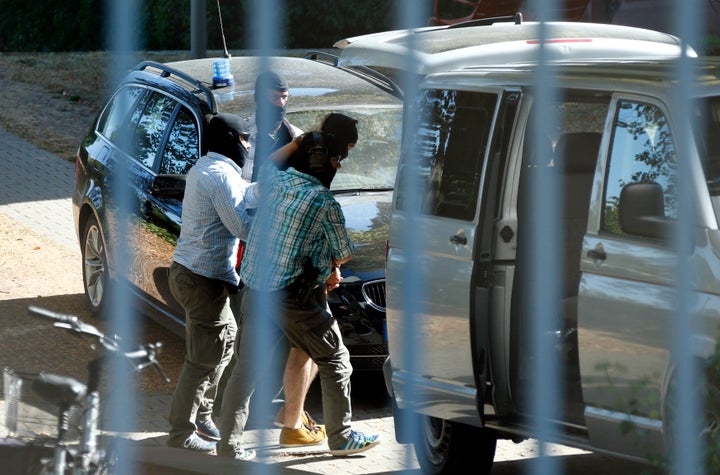 German special police forces escort a Syrian suspected of being members of Islamic State outside the building of the German F