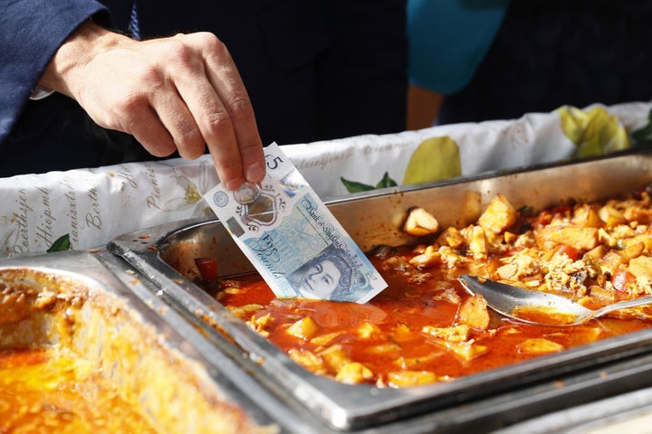 Yep, he's dipping it in the curry