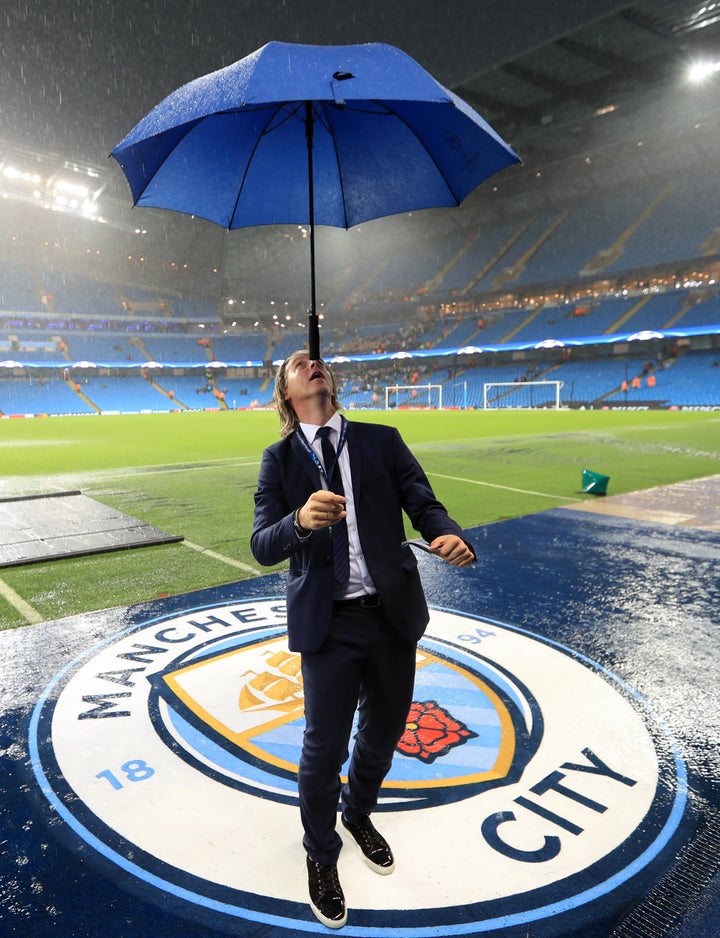 Match officials leave the pitch after inspecting the conditions.