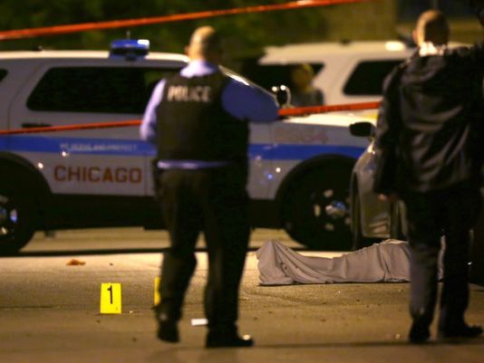 In this May 30, 2016, photo, police work the scene where a man was fatally shot in the chest in Chicago's Washington Park nei
