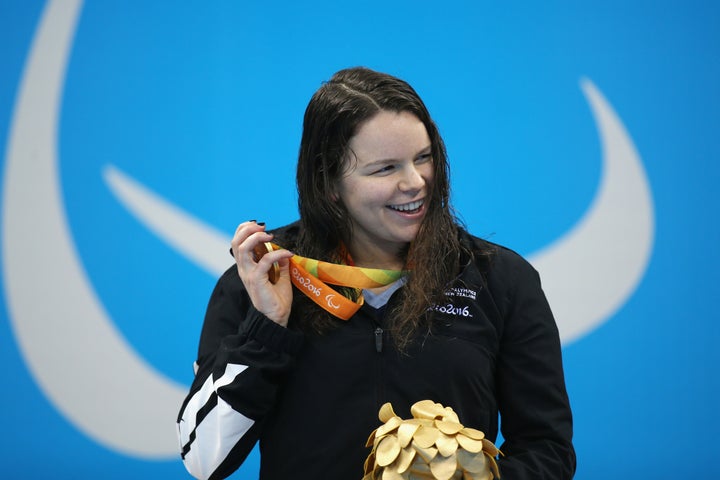 Gold medalist Mary Fisher of New Zealand shakes her medal on the podium for the Women's 100m Backstroke.