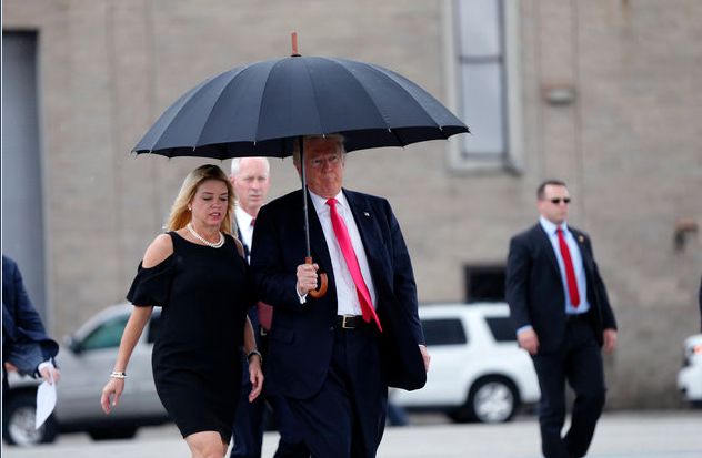 Republican presidential nominee Donald Trump walks in the rain with Florida Attorney General Pam Bondi, as he arrives at a campaign rally in Tampa on Aug. 24.