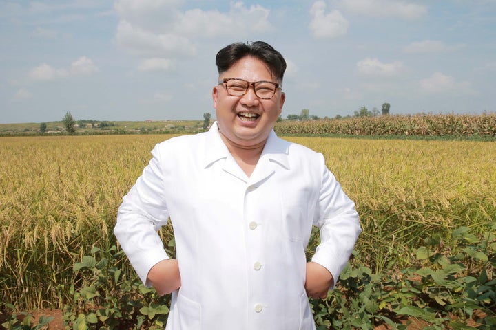 Kim Jong-un laughing in a field.