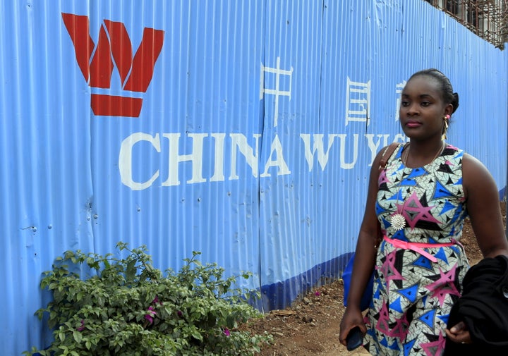 A woman walks past corrugated iron fencing at a Chinese construction site in Kenya's capital Nairobi on September 2, 2015.