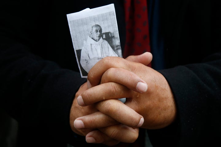 A mourner holds a picture of slain French parish priest Father Jacques Hamel during a funeral ceremony at the Cathedral in Rouen, France, on Aug. 2.