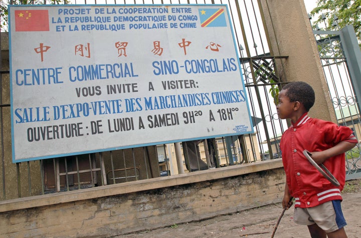 A Congolese boy looks up towards a sign advertising a commercial center selling Chinese products on November 3, 2006 in Kinsh