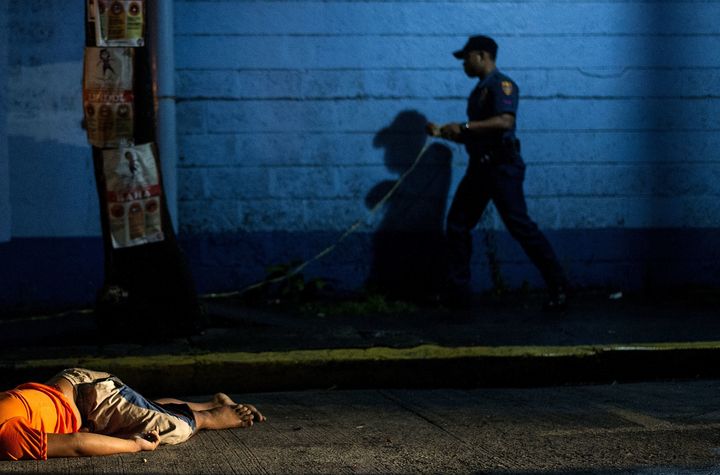 The body of a man, shot dead by unidentified gunmen, lies on the ground in Manila on July 23, 2016.