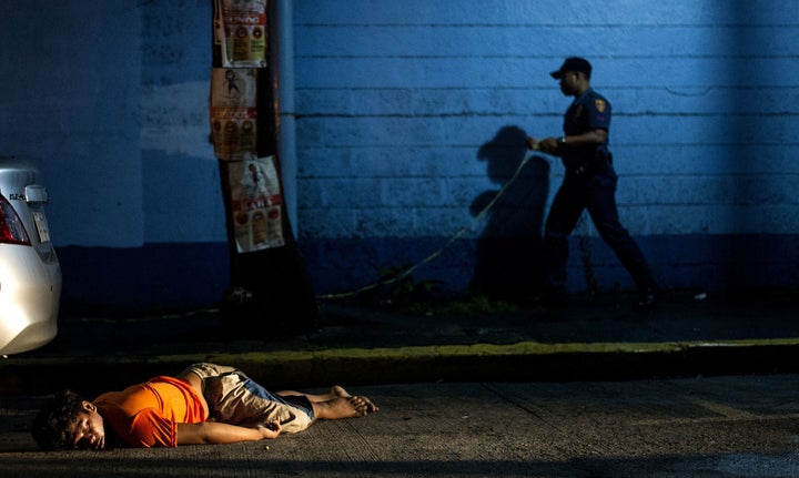 The body of a man, shot dead by unidentified gunmen, lies on the ground in Manila on July 23, 2016.