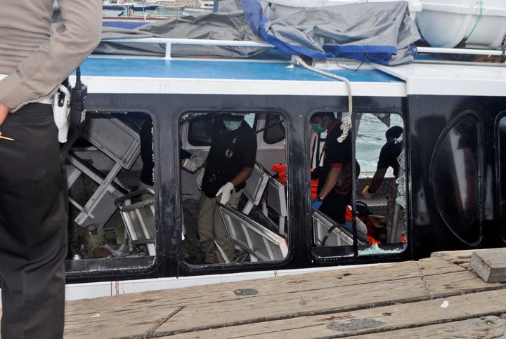 <strong>Police investigators examine the Gili Cat 2 boat following an explosion while it was enroute to nearby island of Lombok</strong>