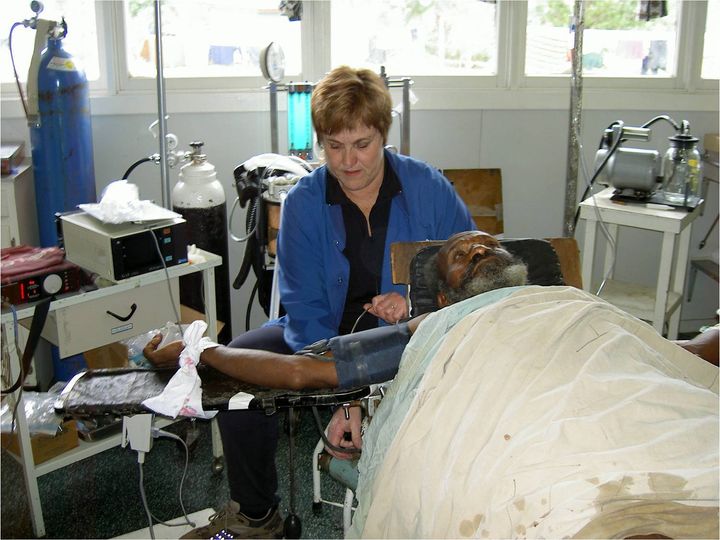 Mary Burry, a radiologist, had to wear many hats while abroad. Here she assists by administering anesthesia to a patient in Papua New Guinea.
