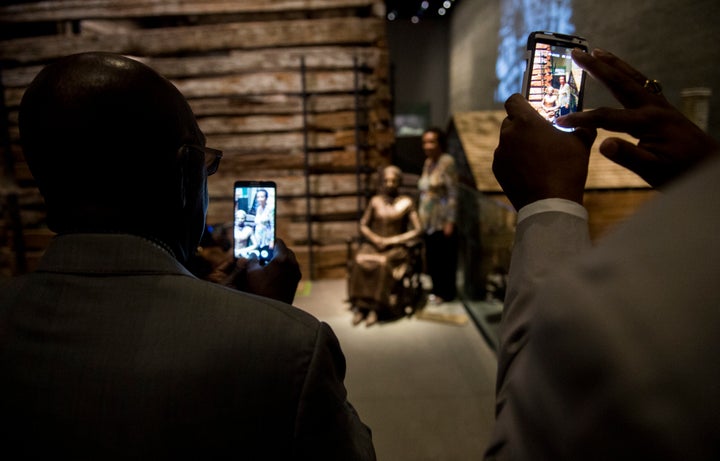 A woman poses with a sculpture of the freed slave Clara Brown.