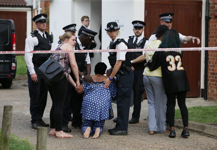 Grieving family members are kept away from the crime scene by police