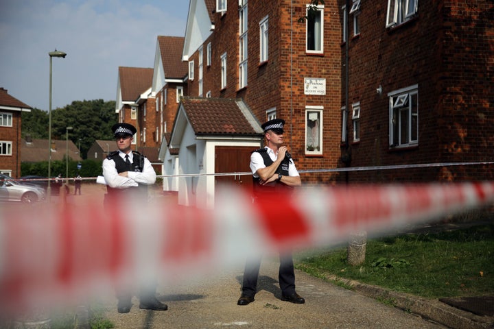 Police officers stand guard outside the flats in Elmshurst Crescent in East Finchley