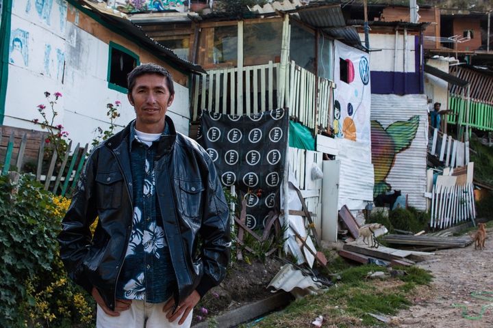 Former peasant farmer Jorge Ariza stands before the shacks of Ciudad Bolivar, a neglected neighborhood of Bogota that is home to tens of thousands of displaced people.