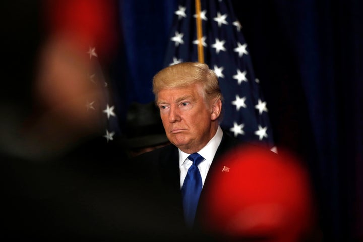 Republican presidential nominee Donald Trump reacts as reporters yell questions after he said he believes President Barack Obama was born in the United States.