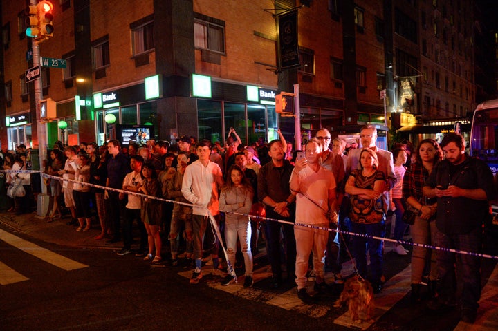 Onlookers stand behind a police cordon near the site of the explosion in the Chelsea neighborhood of Manhattan, New York City, on Saturday night.