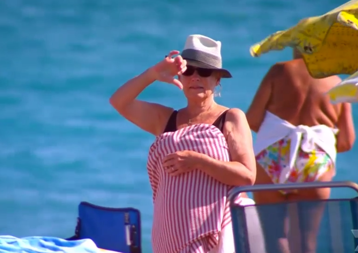 A beachgoer makes her feelings known by giving a 'thumbs down' signal 