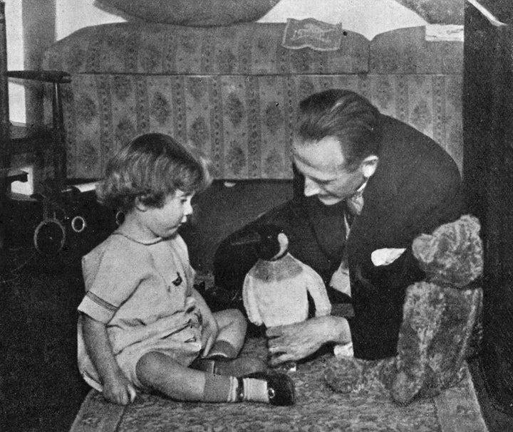 A. A. Milne and his son Christopher Robin Milne playing with a toy penguin.