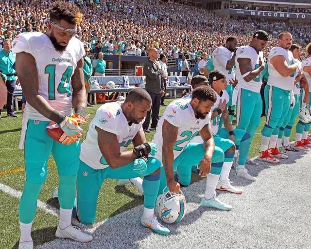 Miami Dolphins protest during the national anthem.