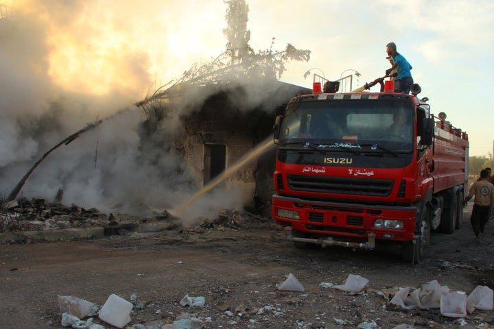 A Civil Defence member and a man put out a fire after an airstrike on the rebel held Urm al-Kubra town, western Aleppo city, Syria.