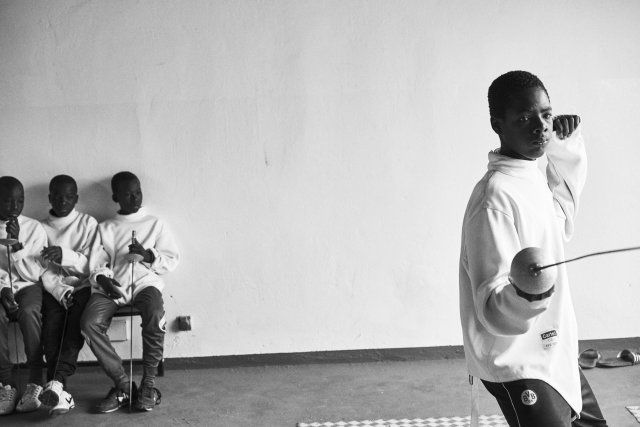 Minors incarcerated at a nearby prison participate in a match during a fencing session at a studio.