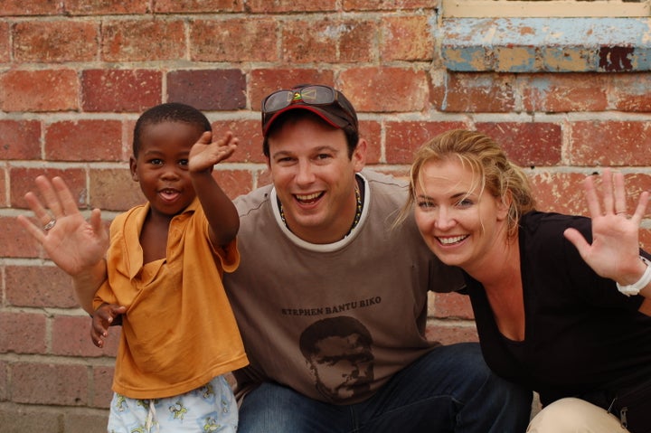 Mark Johnson & Whitney Kroenke with one of the Playing For Change kids