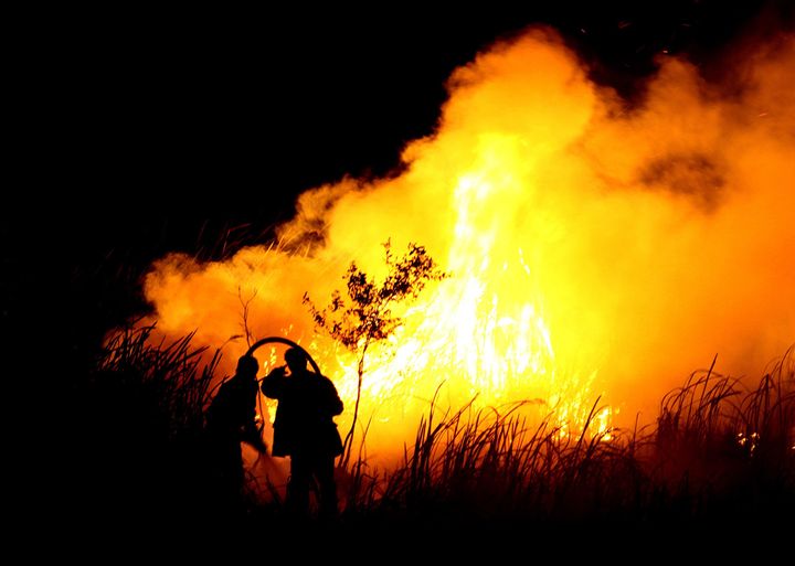Indonesian men put out a fire in Ogan Ilir, southern Sumatra in October 2015.