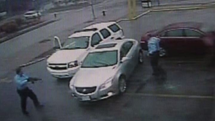 In this photo taken from video footage published by the St. Louis Post-Dispatch, St. Louis police officer Jason Stockley, left, points an unauthorized AK-47 at drug suspect Anthony Lamar Smith's vehicle on Dec. 20, 2011.