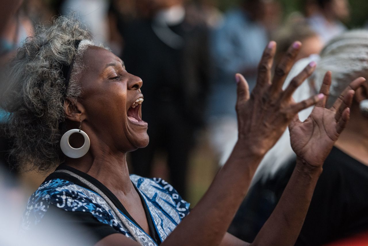 A woman gestures as she participates in a protest at Marshall Park Sept. 21, 2016, in Charlotte, North Carolina.
