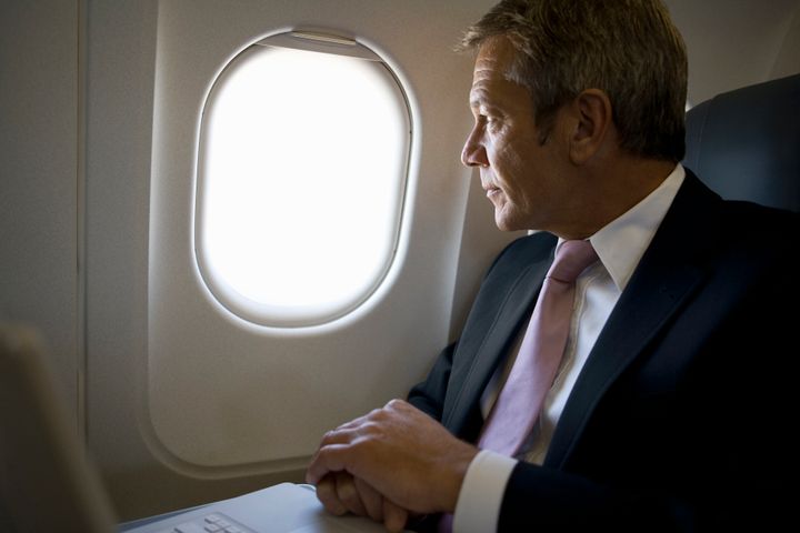 A businessman looking out the window of a plane fStop Images - Halfdark via Getty Images