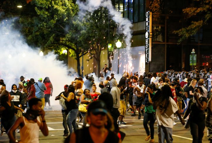 People run from flash-bang grenades in Charlotte during a protest against the shooting of Keith Scott