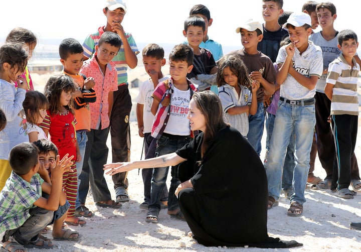 Actress and UNHCR special envoy Angelina Jolie (C) talks to children during a visit to a Syrian refugee camp in Azraq in northern Jordan, on Sept. 9, 2016.