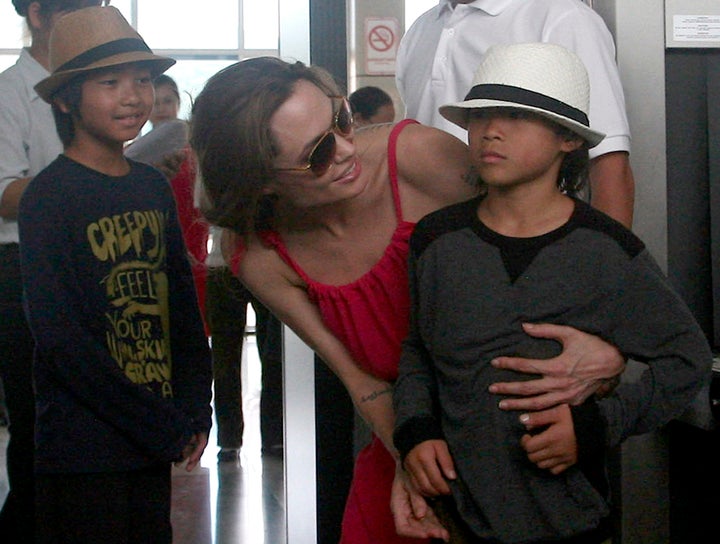Hollywood actress Angelina Jolie (C) chats with her adopted son Pax Thien, from Vietnam, next to Maddox (L), from Cambodia, a