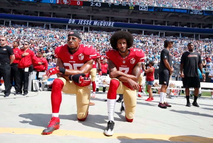 San Fracisco 49ers', Colin Kaepernick #7 (r) and Eric Reid #35 (l) kneel on the sideline, during the anthem, before playing the Carolina Panthers on September 18, 2016, at Bank of America Stadium in Charlotte, N.C.